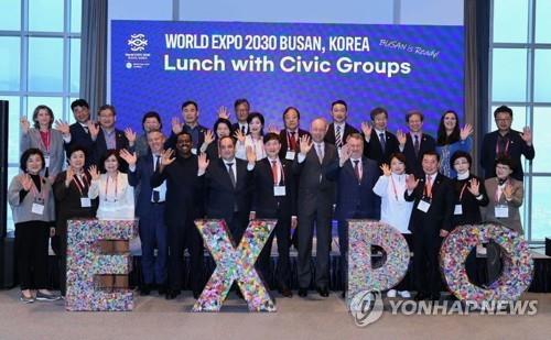 Delegates of the Bureau International des Expositions and representatives of Busan civic groups pose for a photo in the southeastern South Korean port city on April 5, 2023, in front of plastic containers holding 120,000 paper cranes, in this photo provided by the Bid Committee for World Expo 2030 Busan. (PHOTO NOT FOR SALE) (Yonhap)
