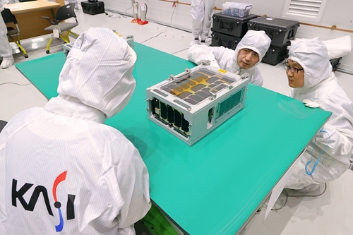 This undated photo provided by the Korea Aerospace Research Institute (KARI) shows officials inspecting a microsatellite developed by the Korea Astronomy and Space Science Institute, codenamed SNIPE, at the Naro Space Center in Goheung, South Jeolla Province. (PHOTO NOT FOR SALE) (Yonhap)
