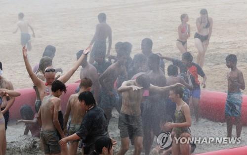 Participants of the 25th World Scout Jamboree enjoy the Mud Mob-Scene festival at Daecheon Beach in Boryeong, central western South Korea, on Aug. 9, 2023. (Yonhap)