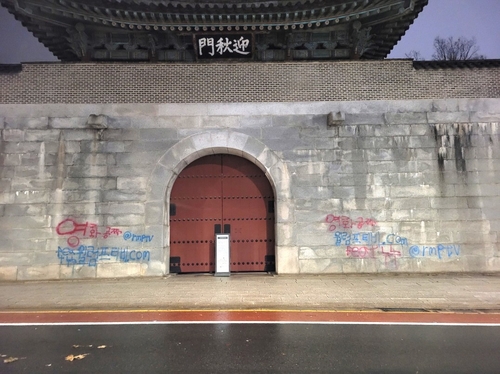 Frases que leen "película gratis" en coreano están pintados en rojo y azul a ambos lados de la puerta occidental del Palacio Gyeongbok en Seúl en esta fotografía proporcionada por la Administración del Patrimonio Cultural el 16 de diciembre de 2023. (FOTO NO A LA VENTA) (Yonhap)