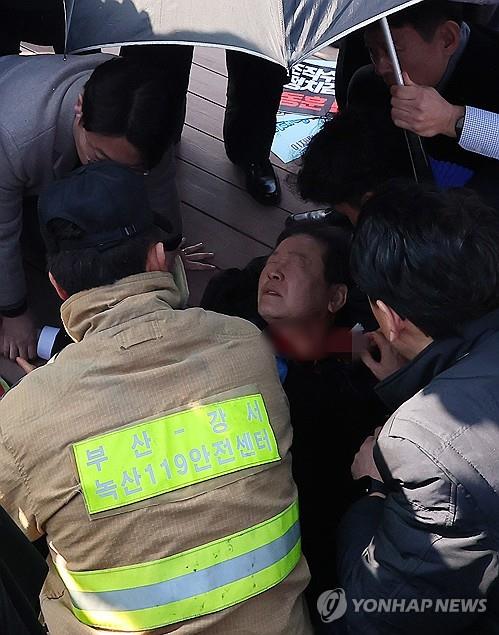 Opposition leader Lee Jae-myung is being treated while waiting for an ambulance after he was stabbed in the neck during a visit to the southeastern port city of Busan on Jan. 2, 2024. (Yonhap)