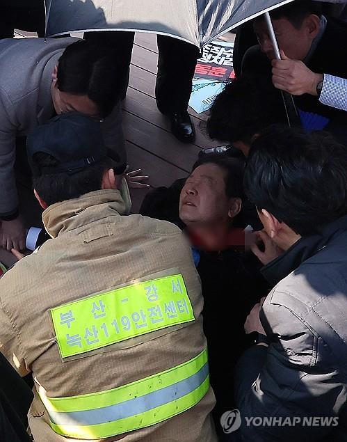 El líder de la oposición Lee Jae-myung está siendo tratado mientras espera una ambulancia después de haber sido apuñalado en el cuello durante una visita a la ciudad portuaria de Busan, en el sureste del país, el 2 de enero de 2024. (Yonhap)