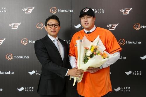 Ryu Hyun-jin of the Hanwha Eagles (R) poses with the club's CEO Park Chan-hyuk after signing with the Korea Baseball Organization team on Feb. 22, 2024, in this photo provided by the Eagles. (PHOTO NOT FOR SALE) (Yonhap)
