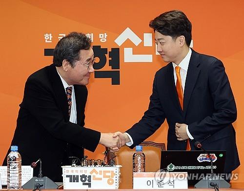 Lee Nak-yon (izq.) y Lee Jun-seok, colíderes del recién creado Partido Reformista, se dan la mano durante una reunión del Consejo Supremo del partido en la Asamblea Nacional en Seúl, el 19 de febrero de 2024. (Yonhap)