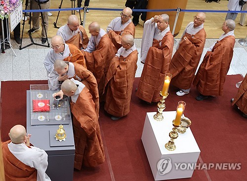 South Korean Buddhist monks look at "sarira" relics of Buddha and two esteemed monks from the 14th-century Goryeo Dynasty (918-1392) during a ceremony held at a museum on Korean Buddhist history and culture in central Seoul on April 19, 2024, to mark their return after 85 years in the Museum of Fine Arts, Boston. (Yonhap)