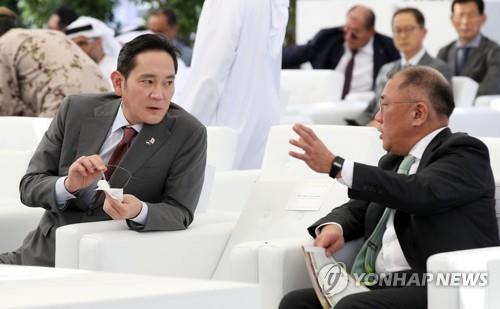 Esta fotografía de archivo del 16 de enero de 2023 muestra al presidente de Samsung Electronics Co., Lee Jae-yong (i), y al presidente de Hyundai Motor Group, Euisun Chung, conversando durante una ceremonia que marca el inicio de las operaciones de la Unidad 3 en la planta de energía nuclear de Barakah en Abu Dabi. , Emiratos Árabes Unidos. (Yonhap)