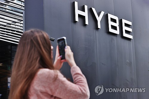 A fan takes a photo outside the headquarters of Hybe in Seoul in this Sept. 25, 2024, file photo. (Yonhap)