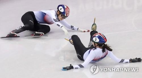 La Sud-Coréenne Choi Min-jeong (à gauche) tombe après une collision avec sa coéquipière Shim Suk-hee lors de la finale du 1.000m féminin de patinage de vitesse sur piste courte aux Jeux olympiques d'hiver de PyeongChang, le 22 février 2018 au Gangneung Ice Arena de Gangneung, à 230 km à l'est de Séoul. (Yonhap)