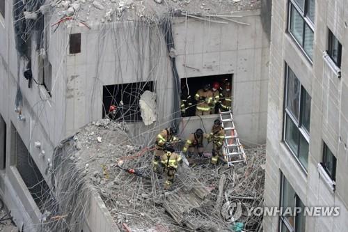 Des secouristent fouillent les décombres le 13 janvier 2022 à la recherche des travailleurs portés disparus lors de l'effondrement d'une façade d'un immeuble d'habitation en construction à Gwangju, dans le sud-ouest du pays. 