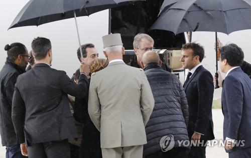 空軍基地でフランス２人と韓国人女性を出迎えるマクロン大統領（右から２人目）＝１１日、パリ（ＥＰＡ＝聯合ニュース）