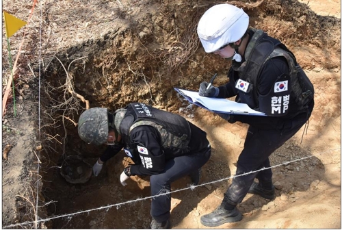 화살머리고지 일대 동굴진지 내부에서 발굴된 유해를 현장감식하는 모습