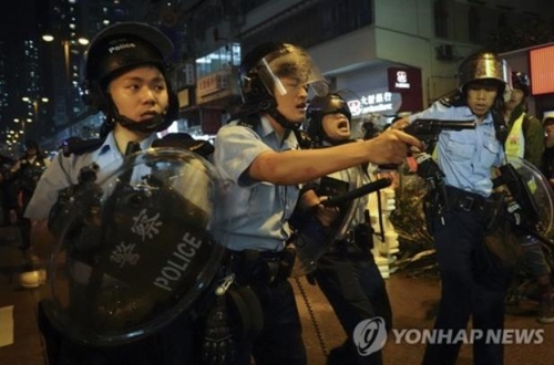 25일 송환법 반대 시위 현장에서 시위대를 향해 권총을 겨누는 홍콩 경찰 / AP통신=연합뉴스