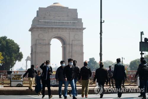 마스크를 쓰고 인도 뉴델리 시내 인디아게이트 앞을 지나는 사람들. [AFP=연합뉴스]