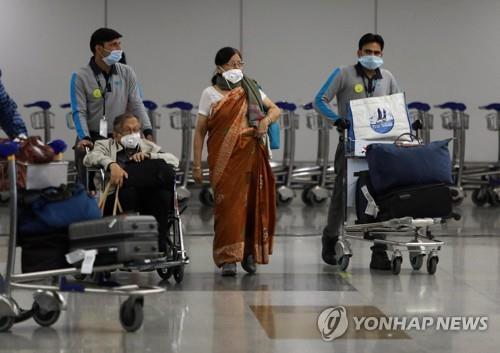 인도 뉴델리의 인디라 간디 국제공항에서 마스크를 쓰고 이동하는 여행객들. [로이터=연합뉴스] 