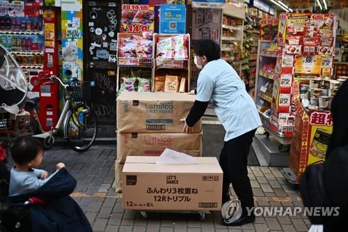 (도쿄 AFP=연합뉴스) 2020년 3월 6일 도쿄의 한 드럭스토어 직원이 휴지 상자를 옮기고 있다.