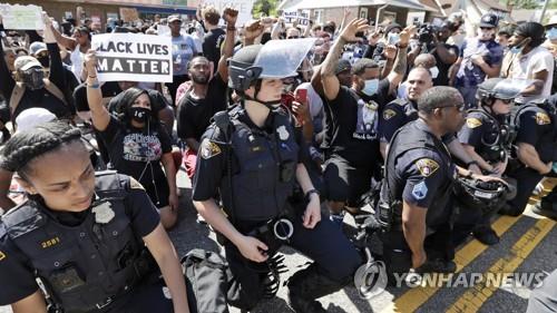 미 클리블랜드 경찰관들이 조지 플로이드 사망 항의시위에 동참해 무릎을 꿇고 있다. [AP=연합뉴스 자료사진]
