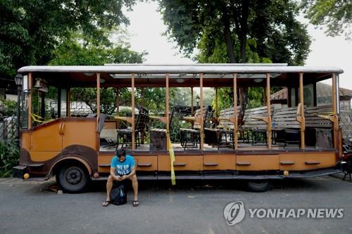 필리핀 마닐라의 관광버스 앞에 한 남성이 앉아 있다. (기사 내용과 상관없음)