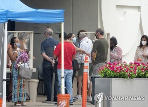 미 플로리다주 마이애미의 잭슨 메모리얼병원 앞에 마스크를 쓴 사람들이 줄 서 기다리고 있다. [EPA=연합뉴스]