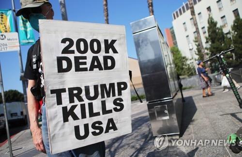 21일(현지시간) 미 캘리포니아주 LA에서 한 남성이 도널드 트럼프 대통령의 코로나19 대처에 항의하는 시위를 벌이고 있다. [AFP=연합뉴스]