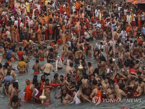 12일 인도 하리드와르의 갠지스강변에서 진행된 쿰브멜라 축제.참가가 대부분은 노마스크 상태로 물에 들어가 축제를 즐겼다. [AP=연합뉴스]
