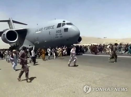 16일(현지시간) 아프가니스탄 카불 하미드 카르자이 국제공항에서 이륙하려는 미국 공군 C-17 수송기를 따라 아프간인들이 달리는 모습을 담은 동영상 캡처. [AP=연합뉴스]