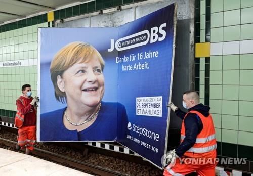 지하철역에서 메르켈 총리에 대한 감사 표시 광고판을 때내는 모습 [로이터=연합뉴스]