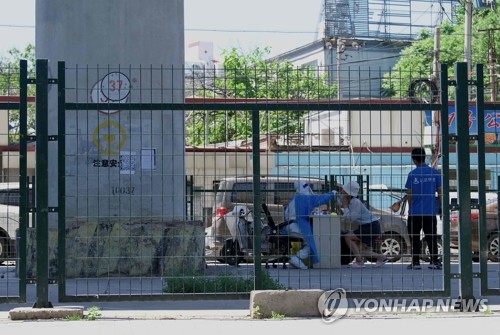 펜스 설치된 주거지역 안에서 코로나 검사받는 베이징 주민
