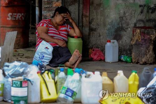등유를 사기 위해 기다리며 쉬고 있는 스리랑카 여성.