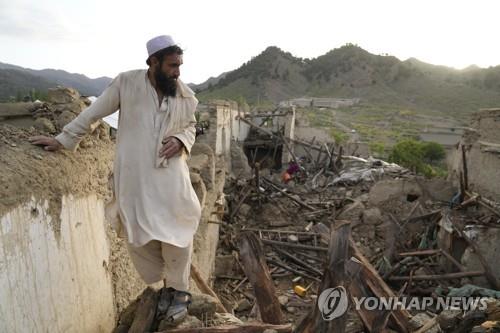아프간 파크티카주에서 강진으로 파괴된 마을을 살펴보는 주민.