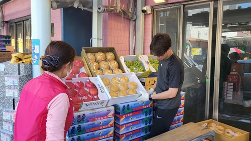 영등포시장의 청과물 가게에서 선물용 과일을 포장하고 있는 상인들.[촬영 설하은]