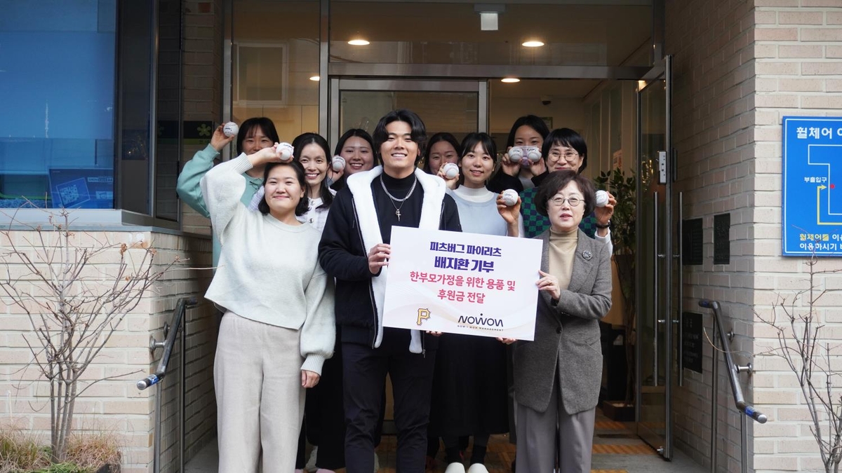 Bae Ji-hwan takes a commemorative photo with officials of a living facility for single mothers.