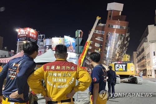 기울어진 건물 바라보는 대만 구조대원들