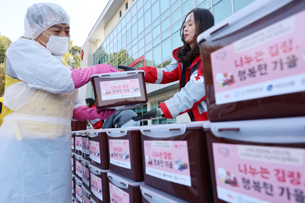 대한적십자사 충북지사 봉사회원들이 29일 청주시 흥덕구 적십자 충북지사 앞마당에서 열린 '사랑 더하기, 김장 나누기' 행사에서 김장김치를 옮기고 있다. 2025.10.29