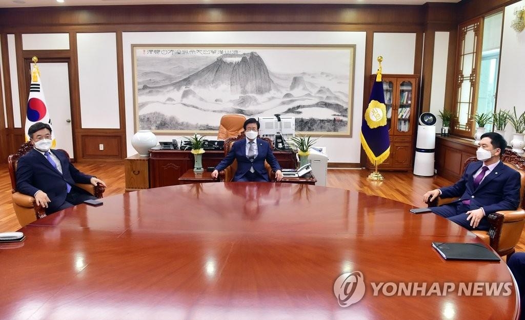 La foto muestra a Yun Ho-jung (izda.), líder parlamentario del gobernante Partido Democrático (DP, según sus siglas en inglés), y Kim Gi-hyeon (dcha.), líder parlamentario de la principal oposición, el Partido del Poder del Pueblo (PPP), sosteniendo una reunión junto con el presidente de la Asamblea Nacional, Park Byeong-seug (centro), durante una reunión en la oficina de Park, en el Parlamento en Seúl, el 29 de septiembre de 2021, para negociar una solución al controvertido proyecto de ley de los medios de comunicación, propuesta por el partido gobernante, el cual ha sido criticado por socavar la libertad de prensa. (Foto del cuerpo de prensa. Prohibida su reventa y archivo) 