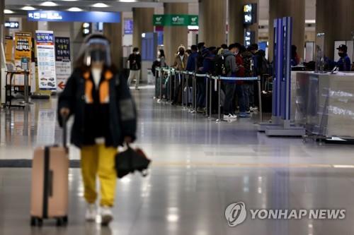 Las personas llegadas desde el extranjero esperan autobuses en el Aeropuerto Internacional de Incheon, al oeste de Seúl, el 30 de noviembre de 2021, en medio de las crecientes preocupaciones por la propagación de la nueva variante Ómicron del coronavirus.