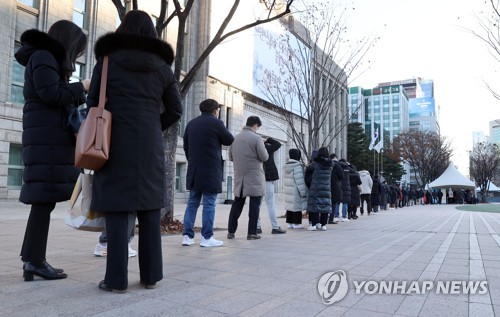 Las personas esperan en fila para someterse a la prueba del COVID-19, el 13 de diciembre de 2021, en una clínica provisional, en el centro de Seúl.