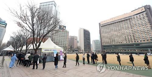 Las personas esperan en fila para someterse a las pruebas del COVID-19, el 11 de marzo de 2022, en una estación de exámenes, en Seúl.