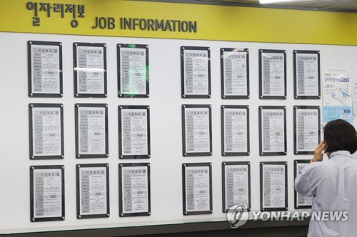 La foto de archivo, tomada el 19 de abril de 2022, muestra a una demandante de empleo observando un tablón de anuncios con información laboral, en una oficina de empleo, en el oeste de Seúl.