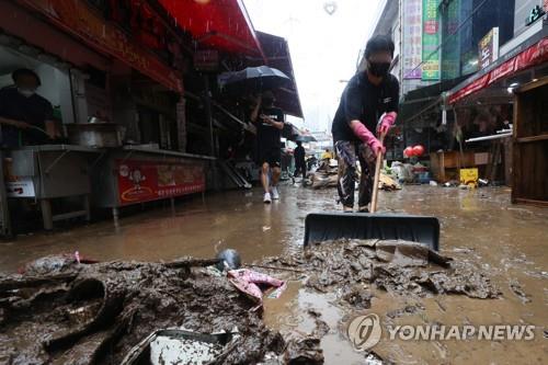 Un comerciante limpia en un mercado tradicional en el distrito de Dongjak de Seúl, el 9 de agosto de 2022, después de que las lluvias récord azotaran la capital el día anterior.