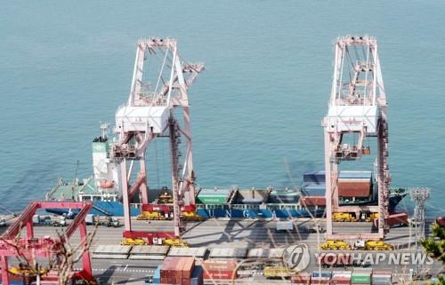 La foto de archivo, tomada, el 10 de marzo de 2023, muestra unas grúas descargando contenedores de un buque en el puerto de la ciudad sudoriental de Busan.
