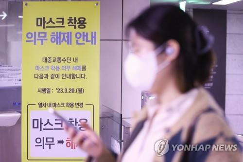 La foto, tomada, el 20 de marzo de 2023, muestra un póster puesto en una estación de metro, en Seúl, indicando que el mandato del uso obligatorio de mascarillas en el trasporte público ha sido eliminado.