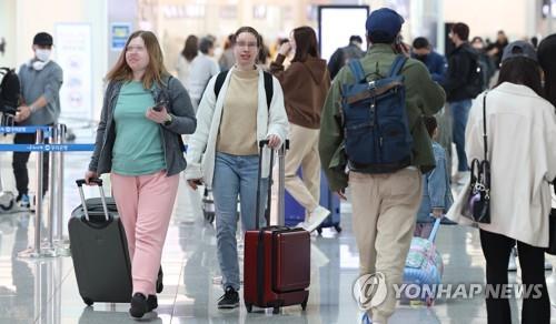 Los viajeros caminan sin mascarillas por el Aeropuerto Internacional de Incheon, al oeste de Seúl, el 20 de marzo de 2023, el primer día de la eliminación del uso obligatorio de mascarillas en el transporte público.