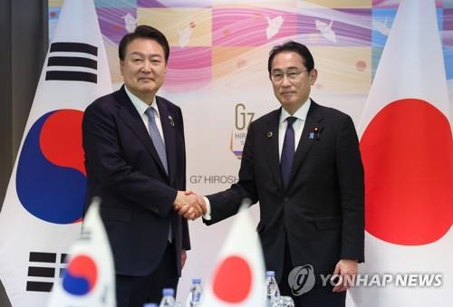 La foto de archivo muestra al presidente surcoreano, Yoon Suk Yeol (izda.), estrechando la mano del primer ministro japonés, Fumio Kishida, durante una cumbre celebrada, el 21 de mayo de 2023, en Hiroshima, Japón.