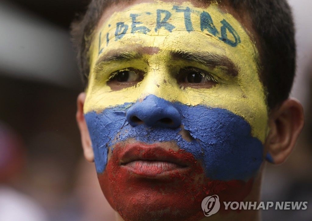 얼굴에 베네수엘라 국기와 '자유' 글씨를 새겨넣은 반정부 시위자 
