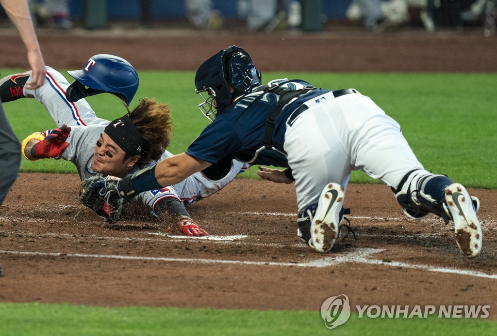 In this Associated Press photo, Choo Shin-soo of the Texas Rangers (L) scores on a double by Joey Gallo during the top of the fourth inning of a Major League Baseball regular season game against the Seattle Mariners at T-Mobile Park in Seattle on Sept. 7, 2020. Choo sprained his right wrist on the play. (Yonhap) 