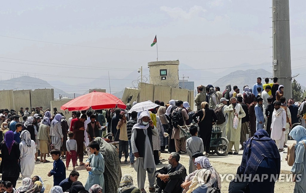 This photo, released by the Associated Press on Aug. 17, 2021, shows people gathering outside the international airport in Kabul, Afghanistan. (Yonhap)