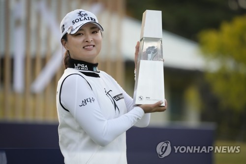 In this Associated Press photo, Ko Jin-young of South Korea holds the champion's trophy after winning the BMW Ladies Championship at LPGA International Busan in Busan, some 450 kilometers southeast of Seoul, on Oct. 24, 2021. (Yonhap)