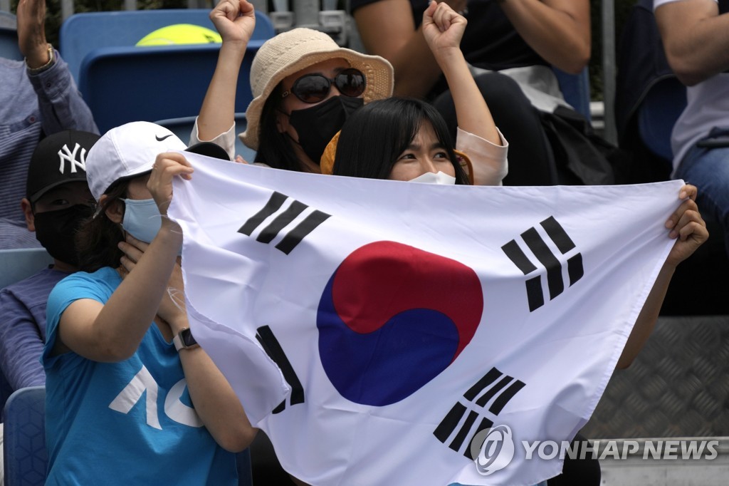 In this Associated Press photo, fans of South Korean tennis player Kwon Soon-woo hold up their national flag, Taegeukgi, during Kwon's first round men's singles match against Holger Rune of Denmark at the Australian Open in Melbourne on Jan. 17, 2022. (Yonhap)
