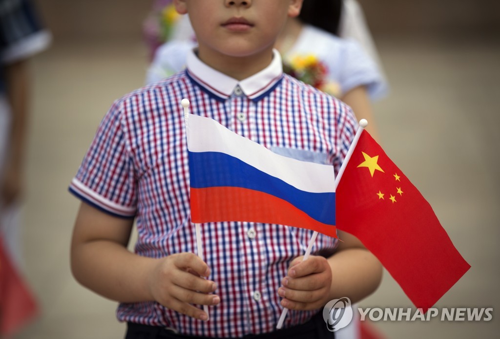 러시아와 중국 국기를 든 중국 소년