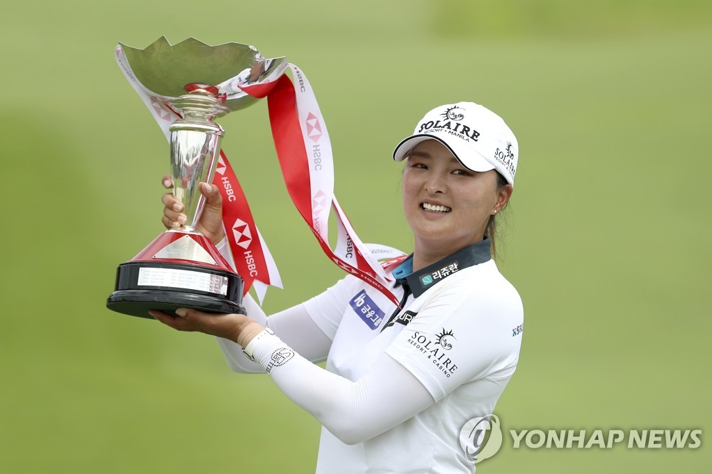In this Associated Press file photo from March 6, 2022, Ko Jin-young of South Korea hoists the champion's trophy after winning the HSBC Women's World Championship at Sentosa Golf Club's Tanjong Course in Singapore. (Yonhap)